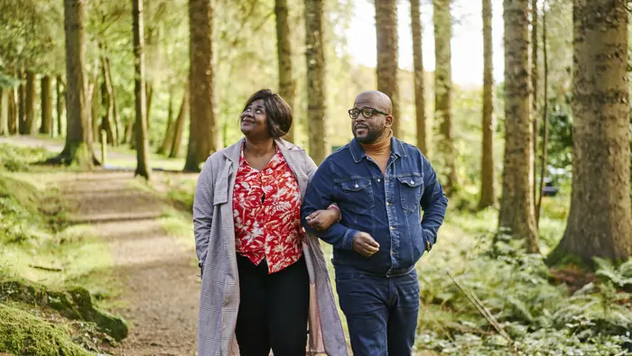 Man and woman stroll together through Kilmun Arboretum
