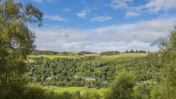 View from hill overlooking fields, houses and woodland, Craigmonie Forest, near Drumnadrochit