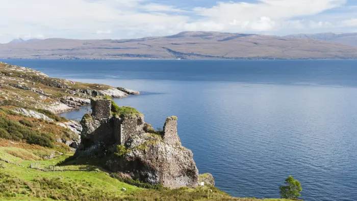 Ruins of a castle next to the coastline.